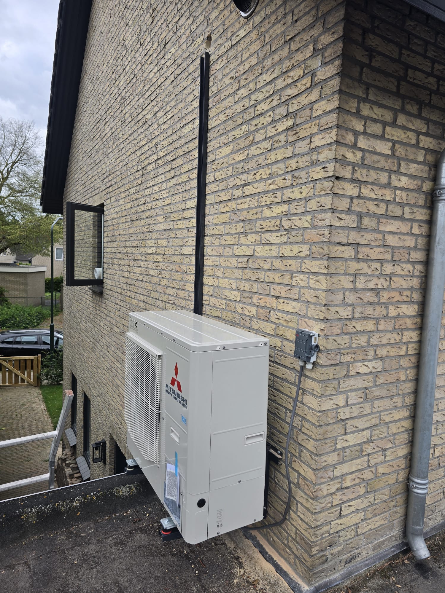 Mitsubishi warmtepomp buitenunit aan woning